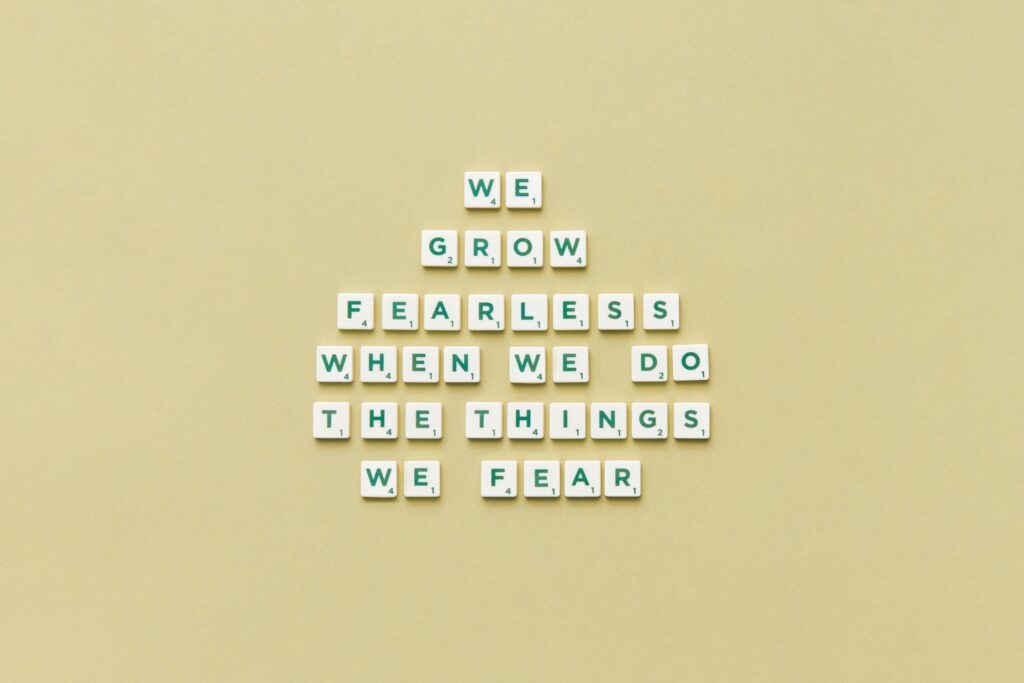 Scrabble pieces arranged to form a motivational quote on a plain background.